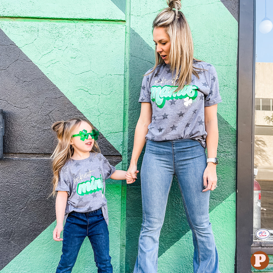 Kids Grey short sleeve tee with dark grey stars on it and says luckiest mini with a small shamrock on the frontKids Grey short sleeve tee with dark grey stars on it and says luckiest mini with a small shamrock on the front